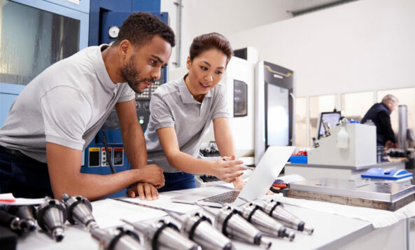 Two Engineers Using CAD Programming Software On Laptop